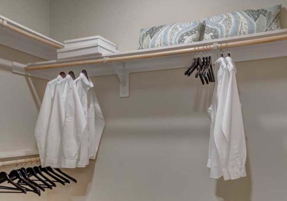 Walk-in closet with built-in shelving, hanging space and towel hooks at Southfork Lake in Manvel, Texas
