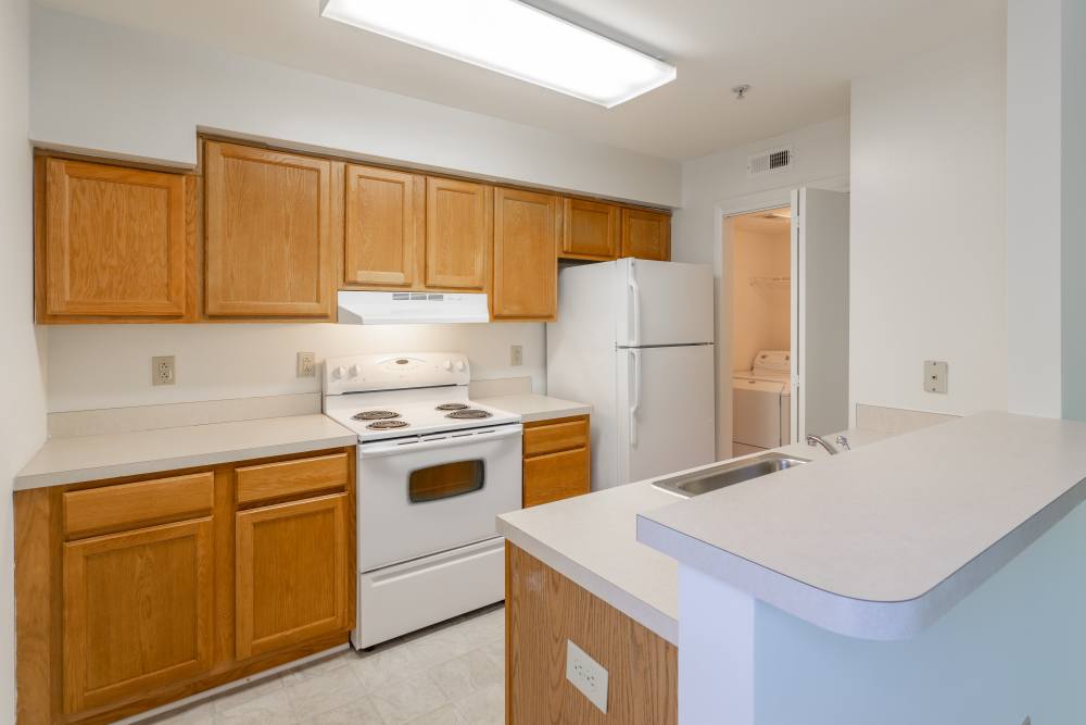 Apartment kitchen with white appliances at Corrigan Square Apartments in Gaithersburg, Maryland