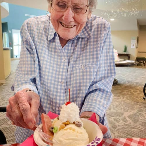 Resident with a large ice cream sundae at The Oxford Grand Assisted Living & Memory Care in McKinney, Texas