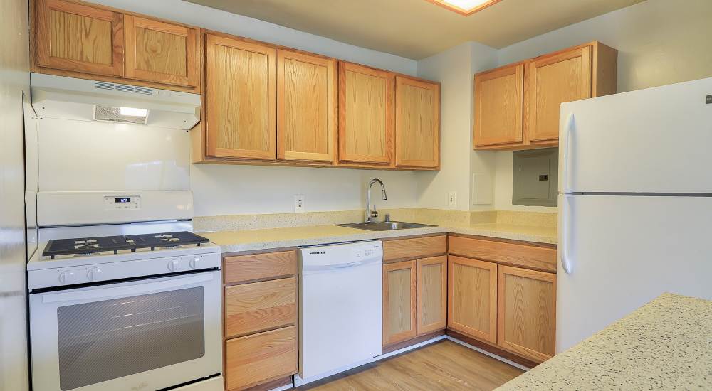 Modern kitchen with wooden cabinets and a refrigerator at Windham Creek in Suitland-Silver Hill, Maryland