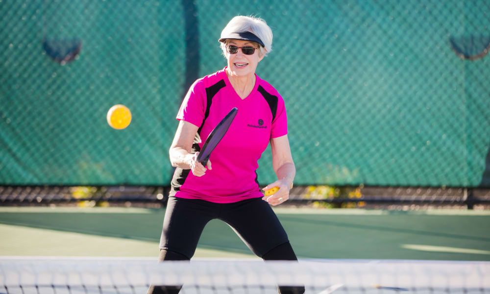 A resident from Touchmark in the West Hills in Portland, Oregon playing tennis