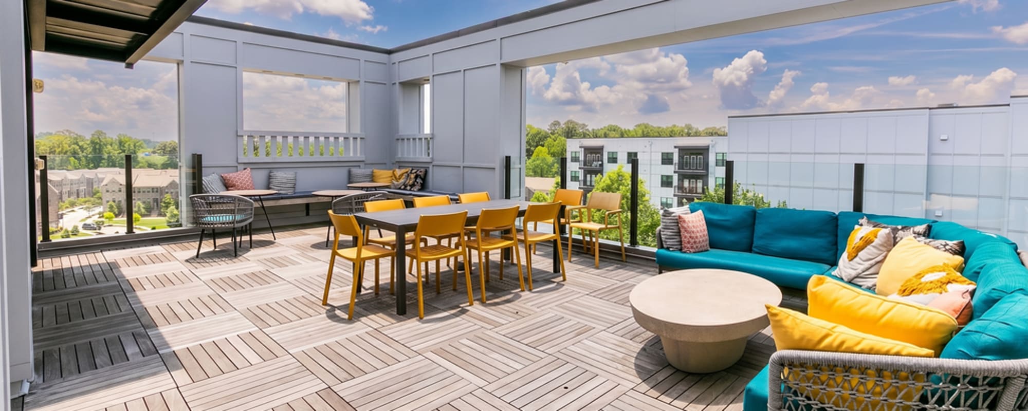 Rooftop lounge with dining table, comfortable seating, and skyline views at Siena Suwanee Town Center in Suwanee, Georgia