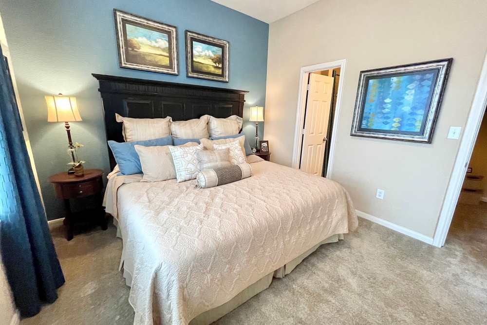 Well-lit bedroom with access to bathroom at The Abbey at Stone Oak in San Antonio, Texas