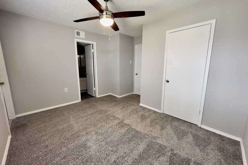 Unfurnished bedroom with carpet flooring and attached bathroom at Villa De Oro in San Antonio, Texas