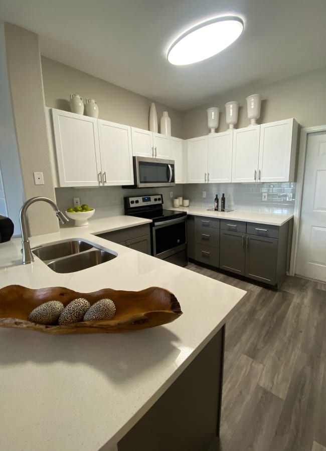 High-end kitchen with quartz countertops and designer cabinetry at Montrachet Apartment Homes in Lakewood, Colorado