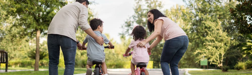 Parents helping their children ride bikes near Residence at Marathon in Columbus, Georgia