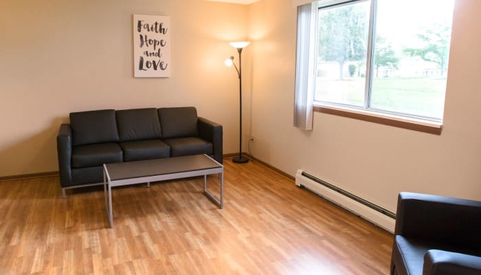 Wood flooring in a bright living room at Campus View & Kirkwood Court in Cedar Rapids, Iowa