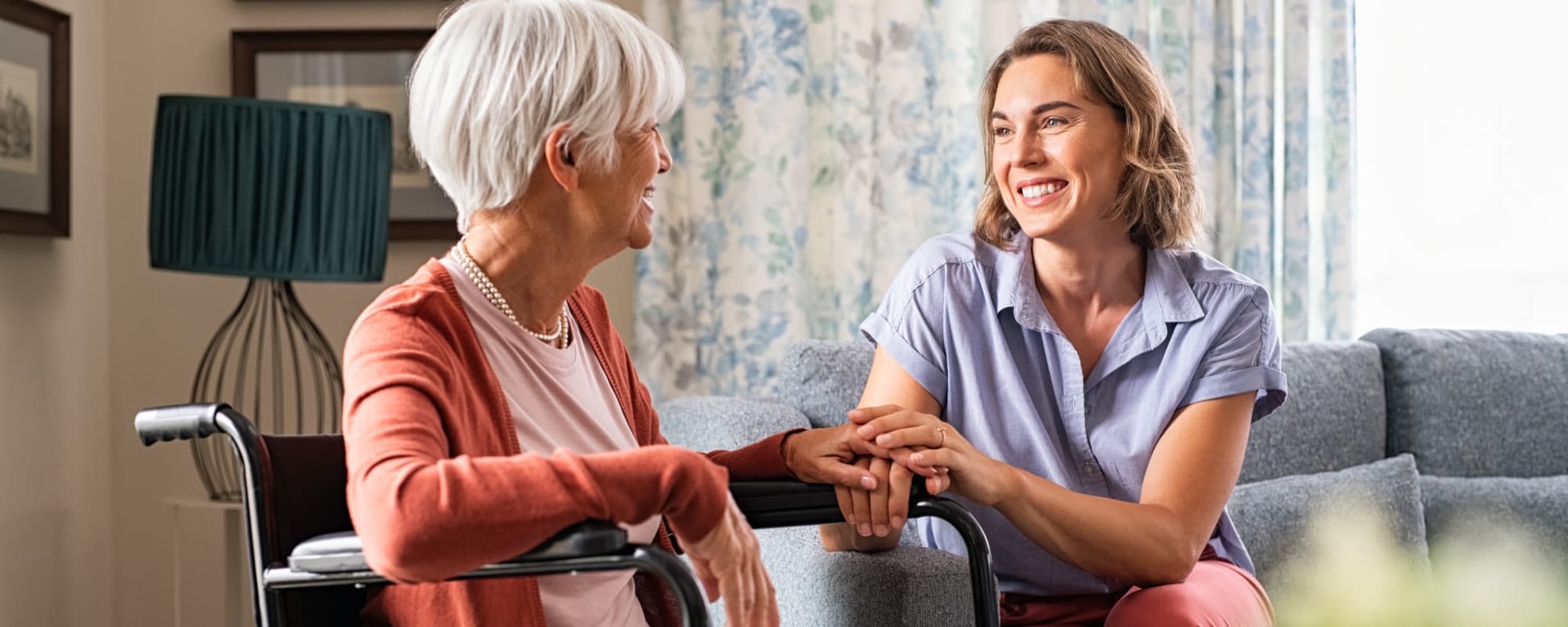 Resident in wheel chair smiling with employee at Ponté Palmero in Cameron Park, California