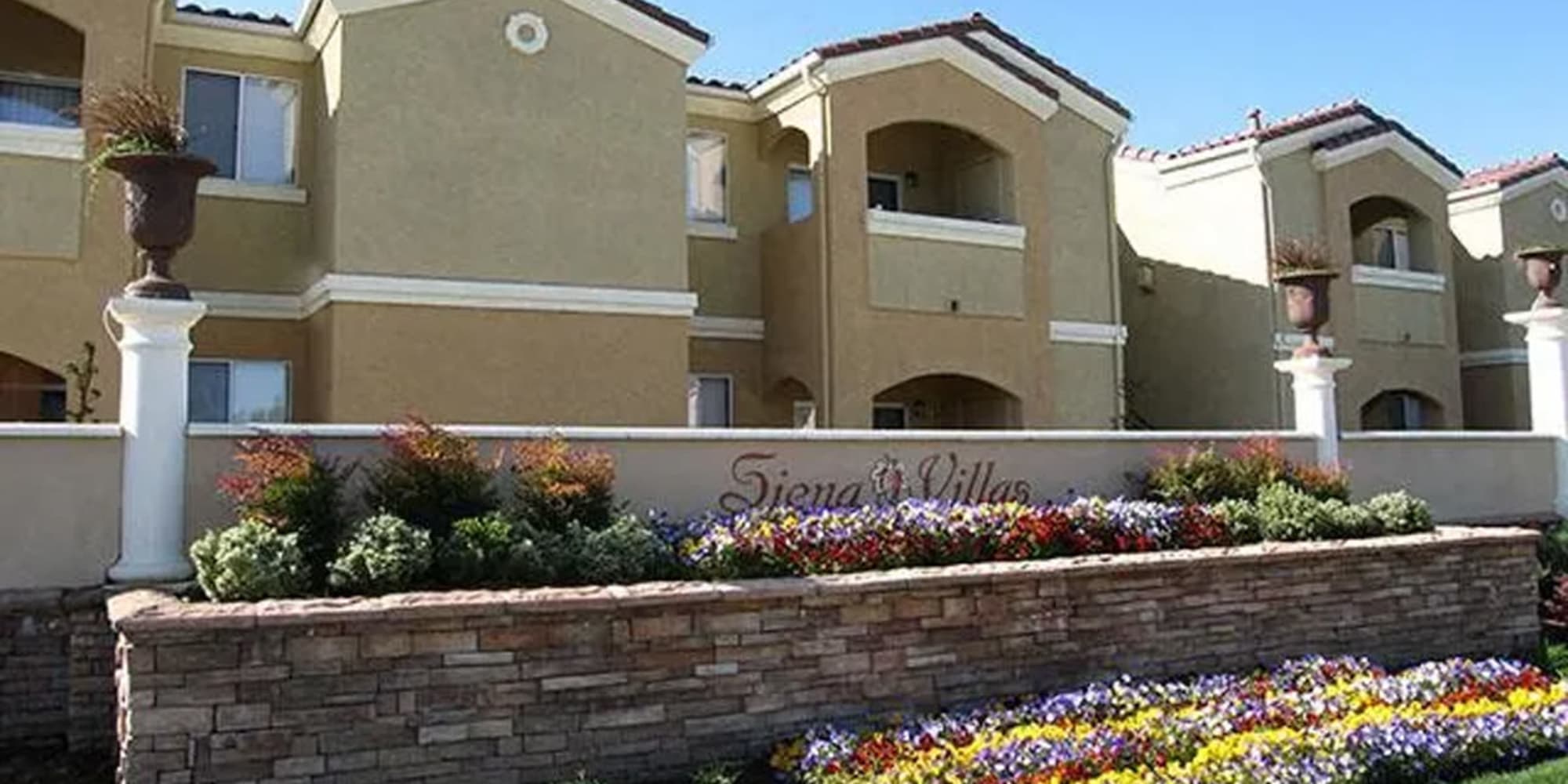 Exterior view with welcome sign at Siena Villas Apartments in Elk Grove, California