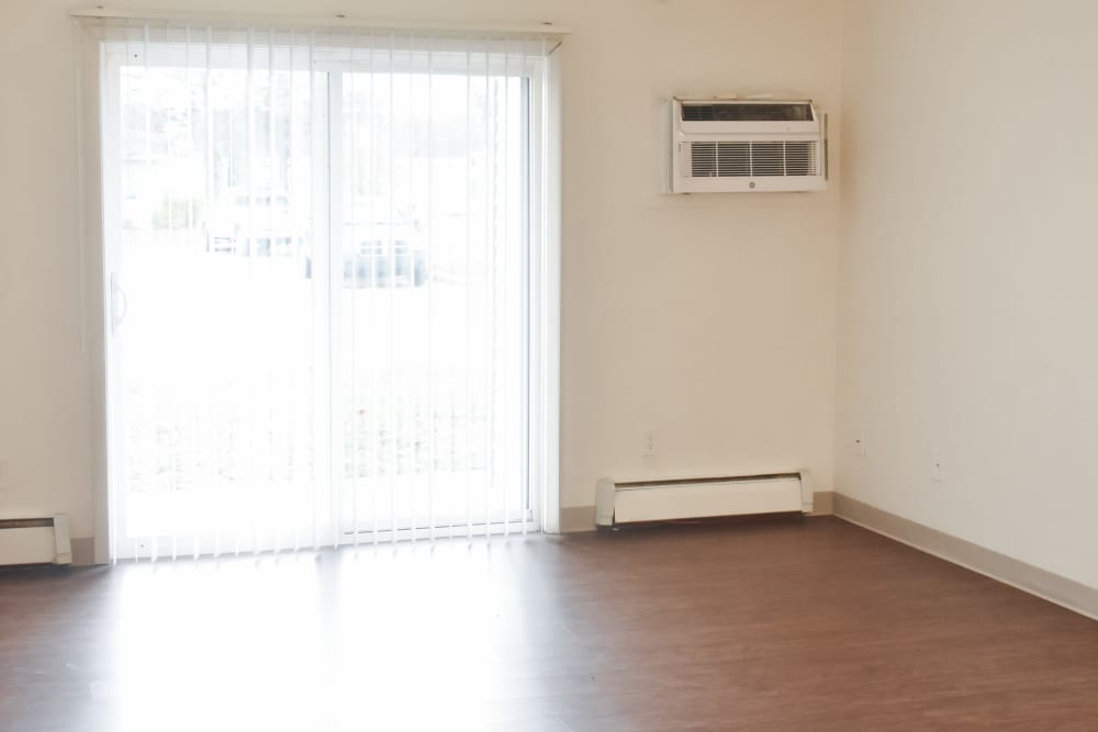 Unfurnished living room with access to private balcony at Lakewood Apartments in Stockbridge, Michigan