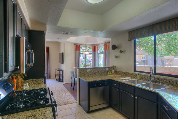 Modern kitchen with granite countertops in apartment home at San Pedregal in Phoenix, Arizona