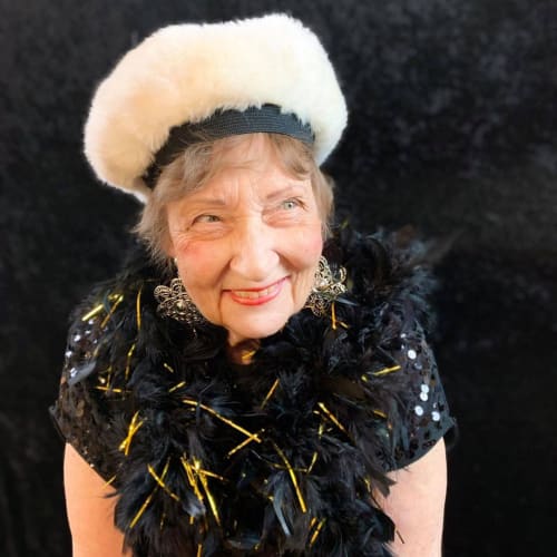 A smiling resident dressed up for an event at Oxford Glen Memory Care at Owasso in Owasso, Oklahoma