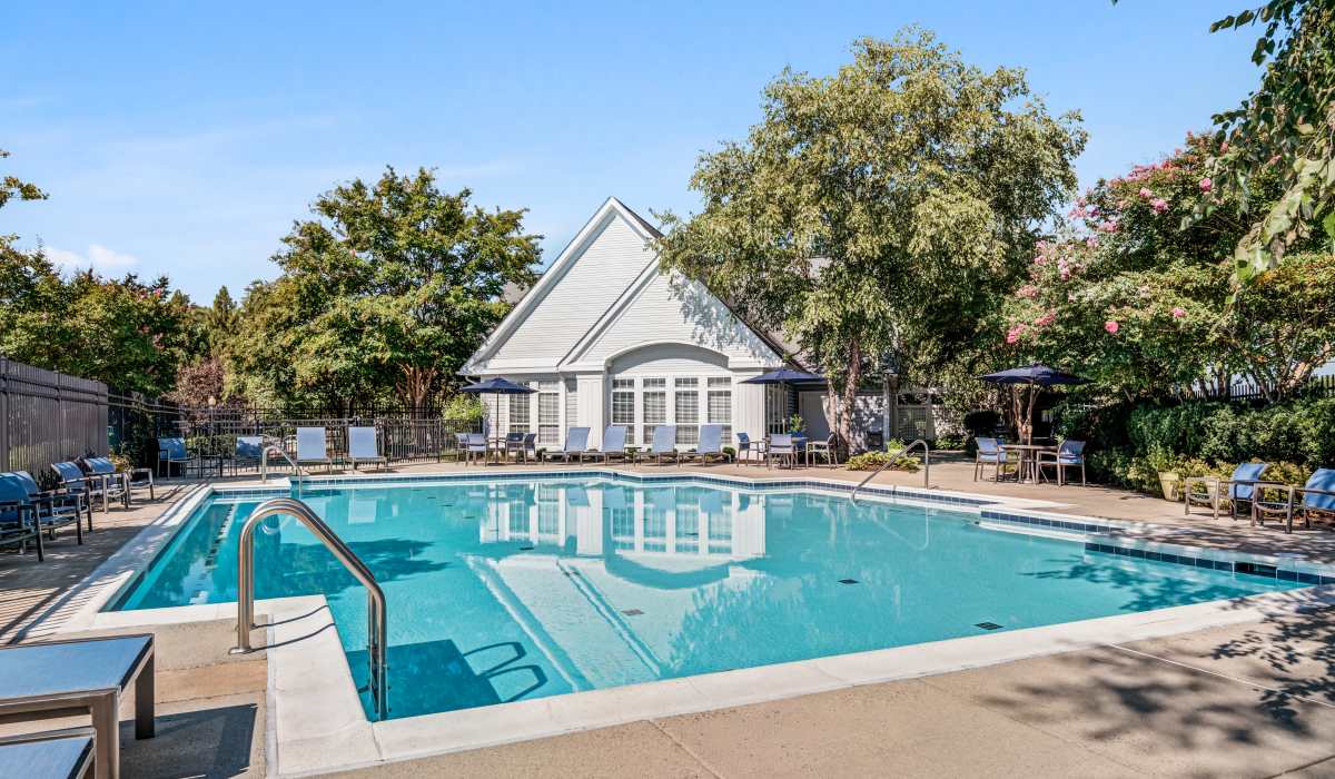 Pool with clubhouse and lounge seating area at Jefferson Arbors at Broadlands in Ashburn, Virginia 