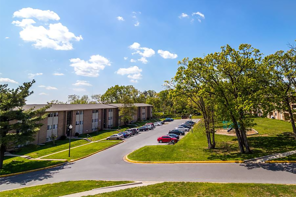 Green space and parking outside of Tuscany Woods Apartments in Windsor Mill, Maryland