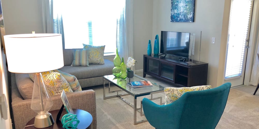 Modern furnishings and large bay windows in a model home's living area at Level at 401 in Raleigh, North Carolina