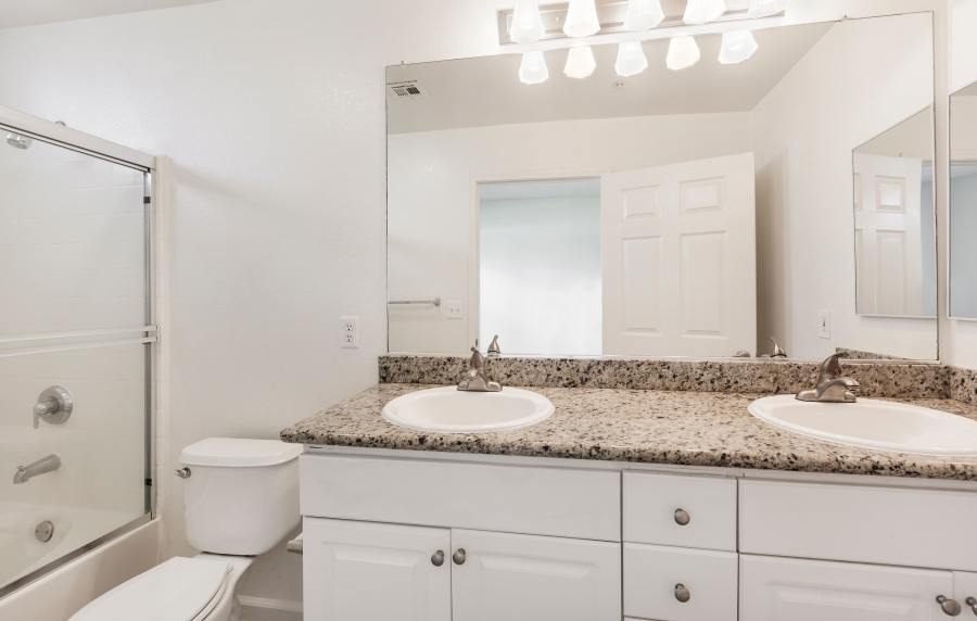 Modern bathroom with large mirror at Park Hacienda Apartments in Pleasanton, California