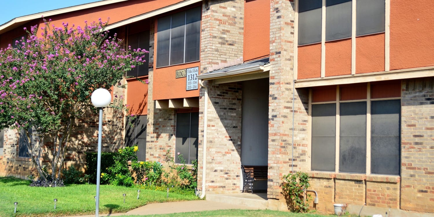 Flowers blooming outside and apartment building at Villa Bella apartments in Euless, Texas