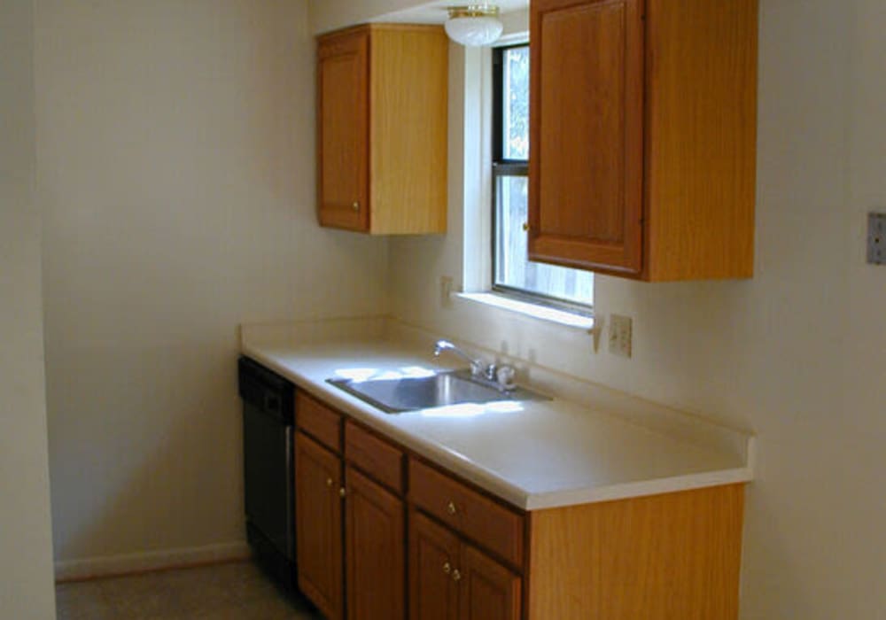 Kitchen with wooden cabinets and sink at Jefferson Manor Townhomes in Fairport, New York