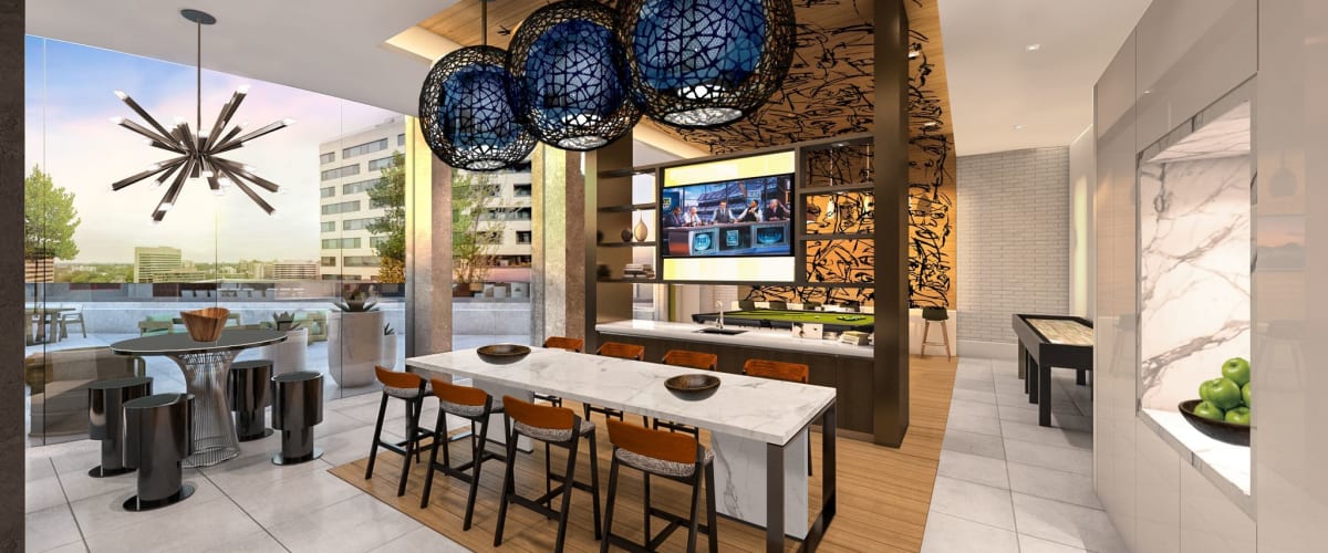 Resident lounge with a large flatscreen TV, billiards table, and shuffleboard at Solaire 8200 Dixon in Silver Spring, Maryland