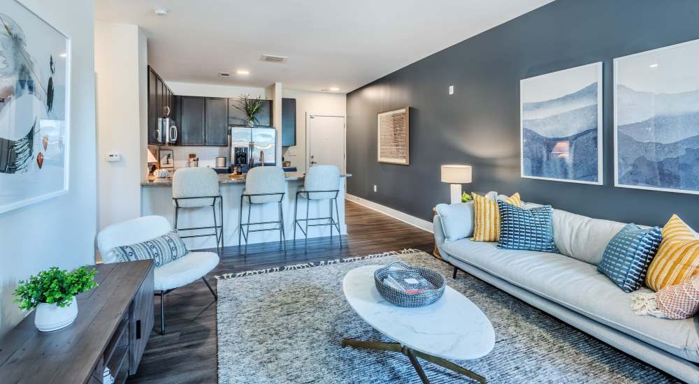 Living room with large couch, chair, coffee table and view to kitchen at Gateway West in Charlotte, North Carolina