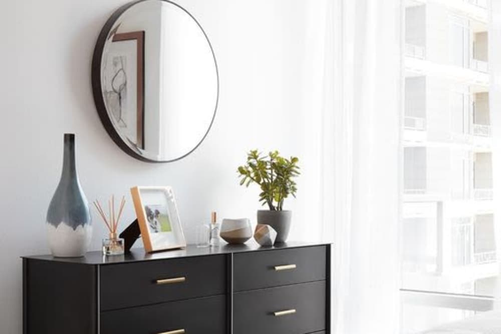 Wall-mounted mirror and storage unit along with large window at Ardan in Dallas, Texas