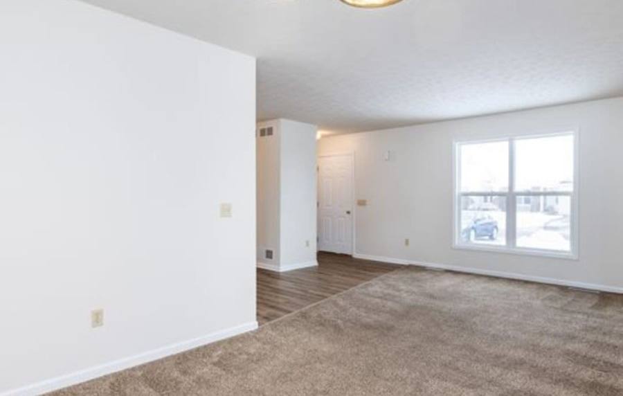 Spacious living space with soft carpeting and natural light at Unionville Station Townhomes in Hilton, New York