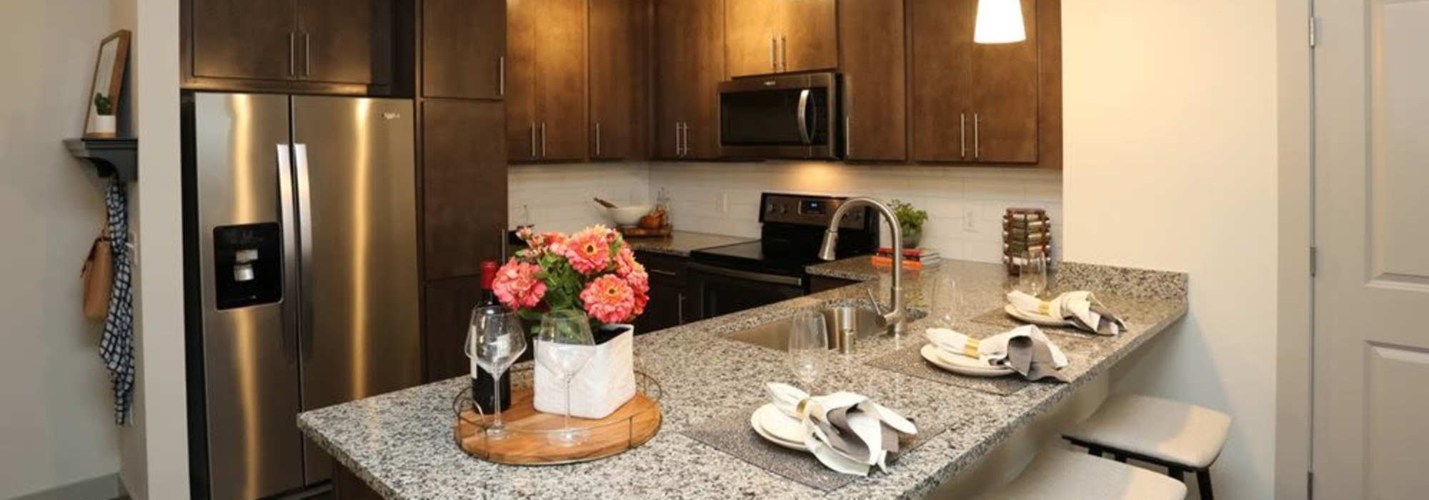 Kitchen with wooden cabinets and granite countertops at The Marling in Madison, Wisconsin