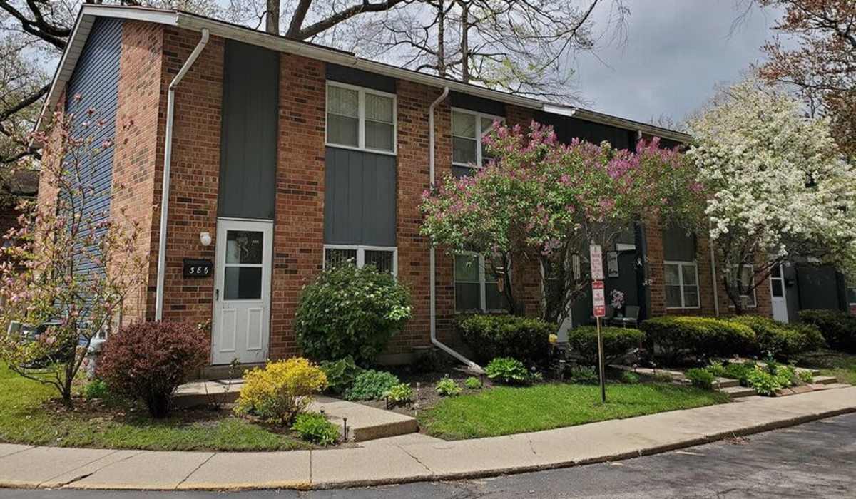 Charming brick-front townhouse surrounded by lush landscaping at The Reserve at Pin Oak Manor Apartments in Mishawaka, Indiana