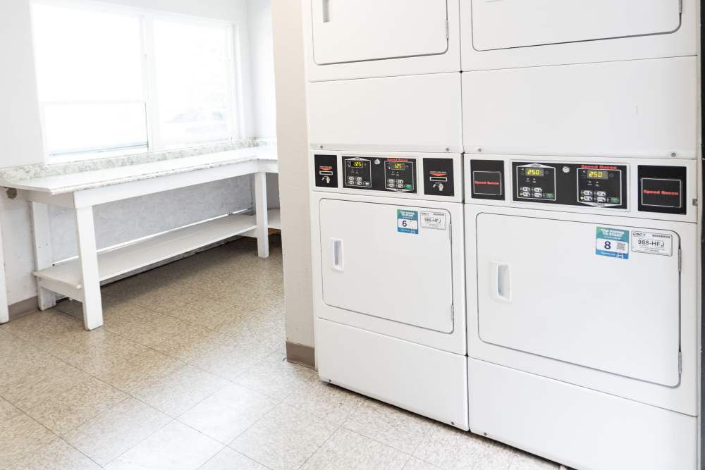 Sleek laundry area featuring modern appliances and ample counter space at San Mateo Forest in Dallas, Texas.