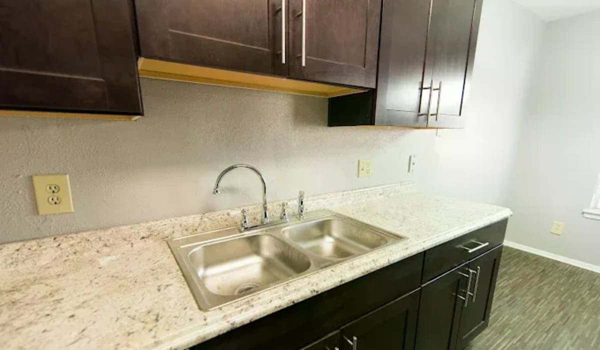 Apartment kitchen with wooden cabinets and countertops at Tradewind Apartments in Mesquite,Texas