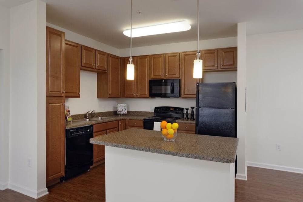 Kitchen with wooden cabinets at Adams Crossing Apartment Homes in Waldorf, Maryland