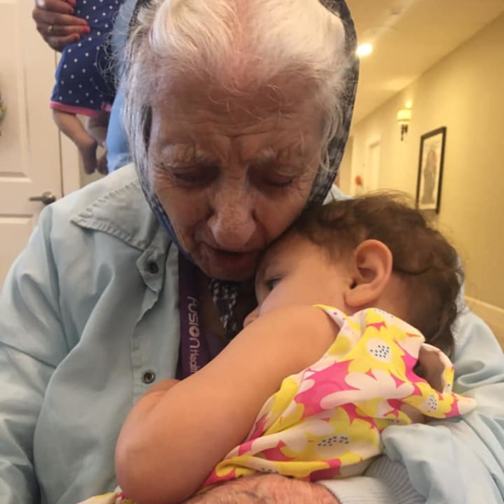 A resident holding a baby at Inspired Living Sun City Center in Sun City Center, Florida.