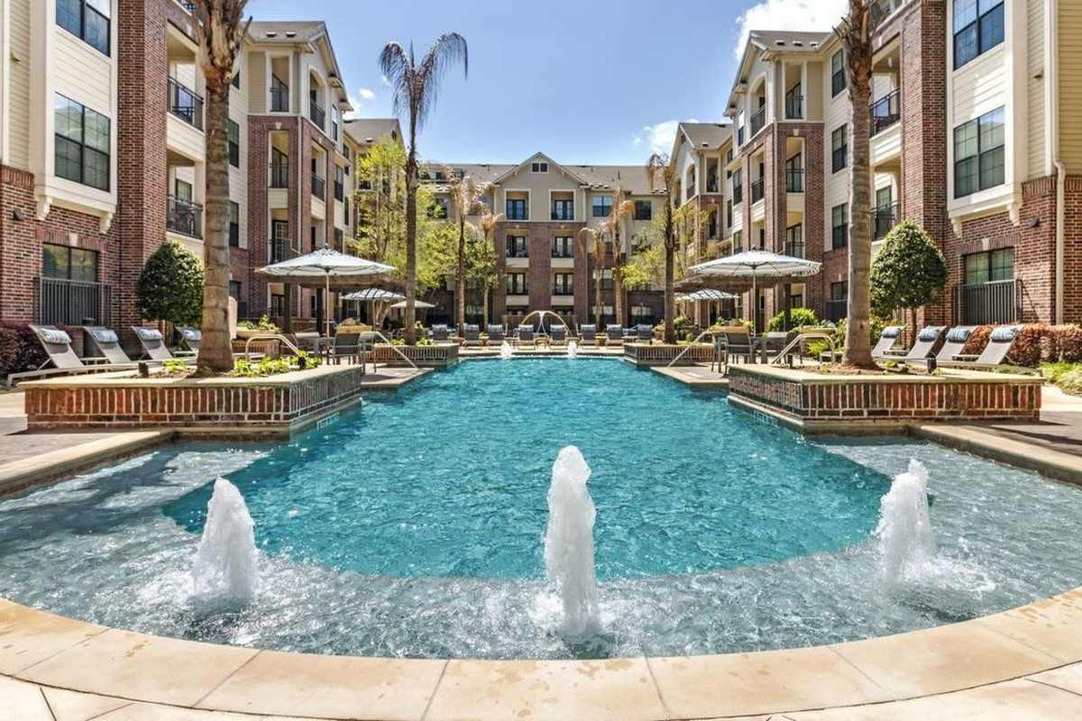 Community swimming pool and patio with lounge chairs at Villas At Bunker Hill, Houston, Texas
