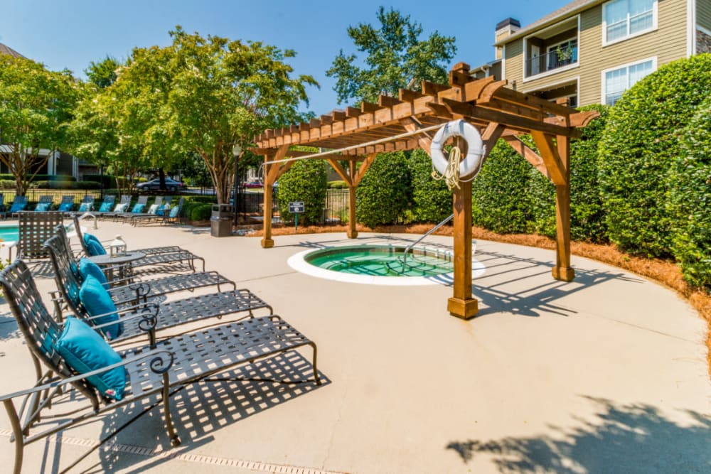 Partially shaded hot tub area with lounge chairs at Marquis at Carmel Commons in Charlotte, North Carolina