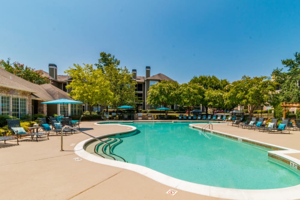 Sparkling pool with lounge chairs surrounding at Marquis at Carmel Commons in Charlotte, North Carolina