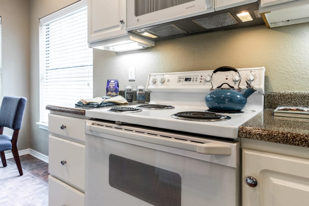 Bright kitchen with laminate counters and white cabinets at Marquis at Waterview in Richardson, Texas