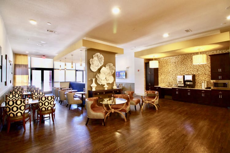 Bright and inviting breakfast lounge with tables and chairs neatly arranged, offering a comfortable space for residents to enjoy morning meals at Watermere at Frisco in Frisco, Texas