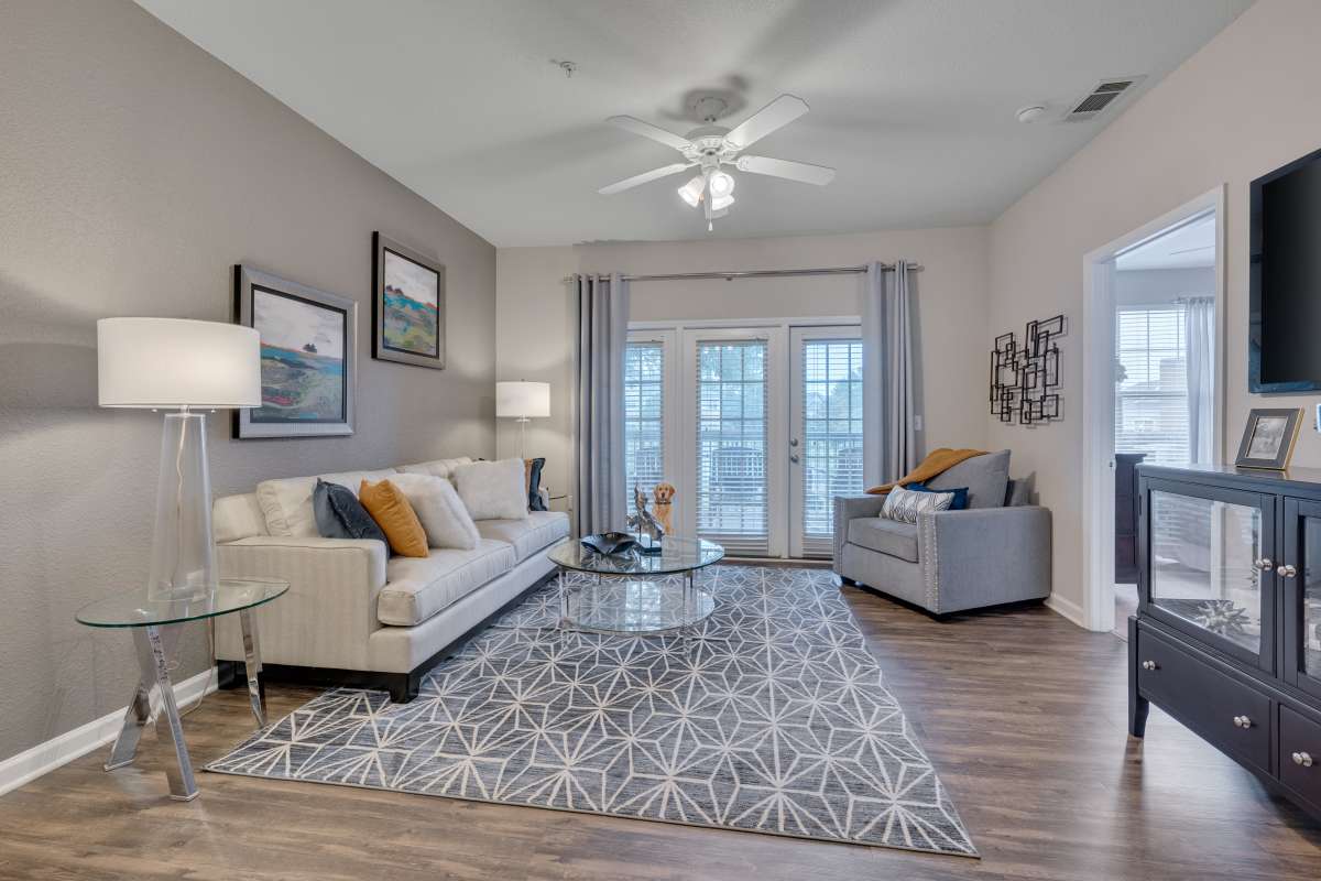 Spacious living room with large couch, chair and coffee table at Kildaire Reserve Apartments, Cary, North Carolina