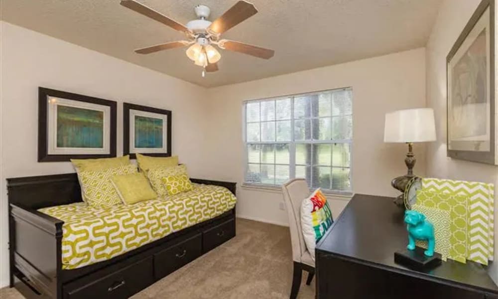 A ceiling fan and plush carpeting in a furnished bedroom at The Granite at Porpoise Bay in Daytona Beach, Florida