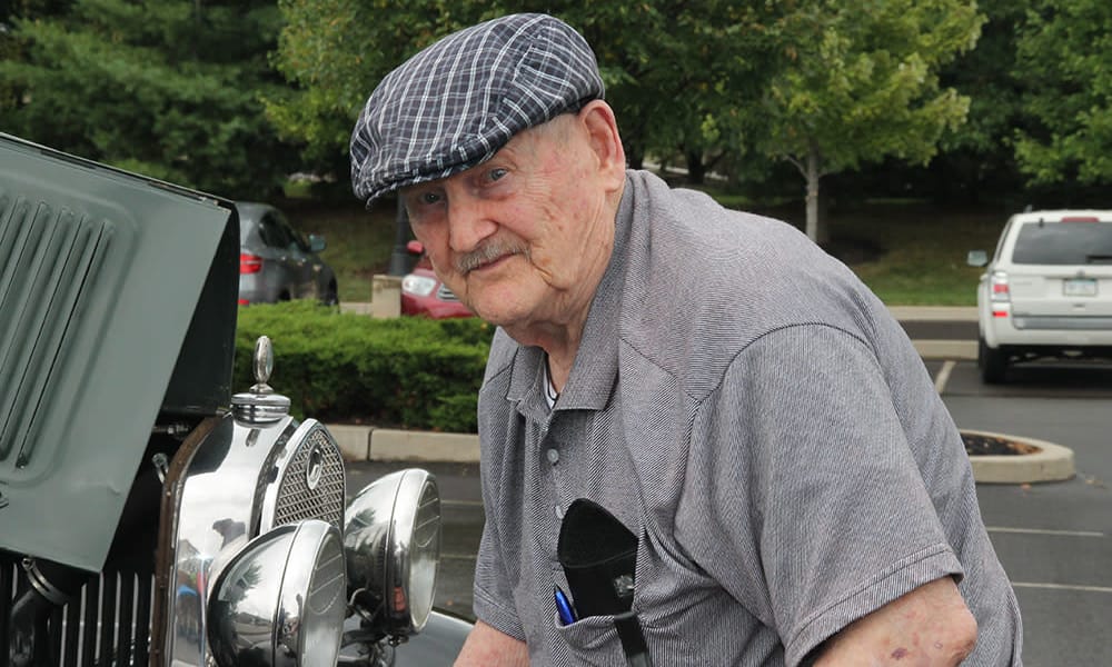 Resident standing next to an old vehicle at The Birches at Harleysville in Harleysville, Pennsylvania