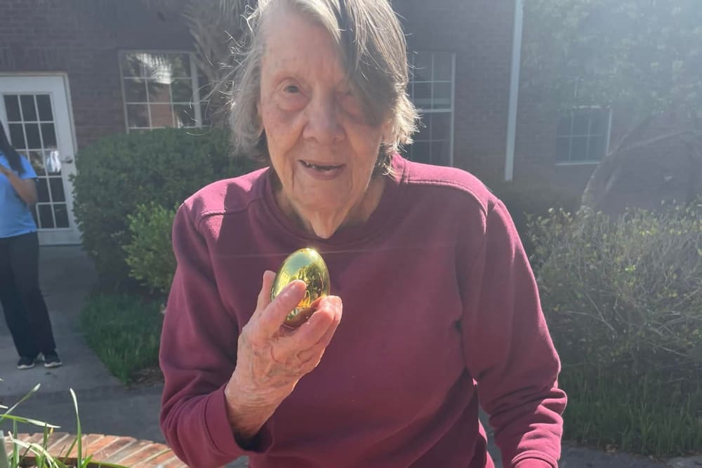 A resident holding an Easter egg at Lavender Hills Front Royal Campus in Front Royal, Virginia