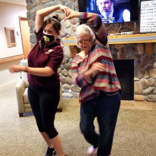 Resident and a masked caretaker dancing at The Oxford Grand Assisted Living & Memory Care in Wichita, Kansas