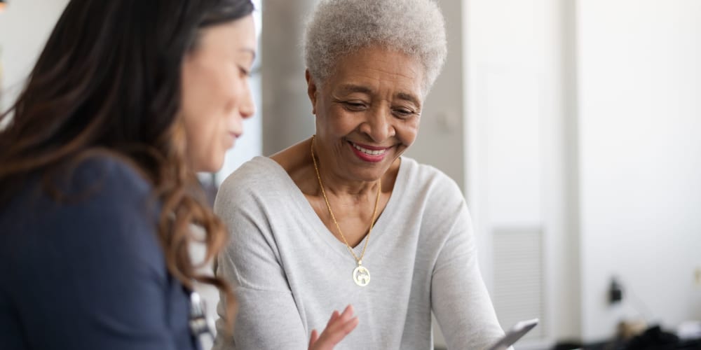 Staff member helping a resident at The Heritage Memory Care in The Woodlands, Texas