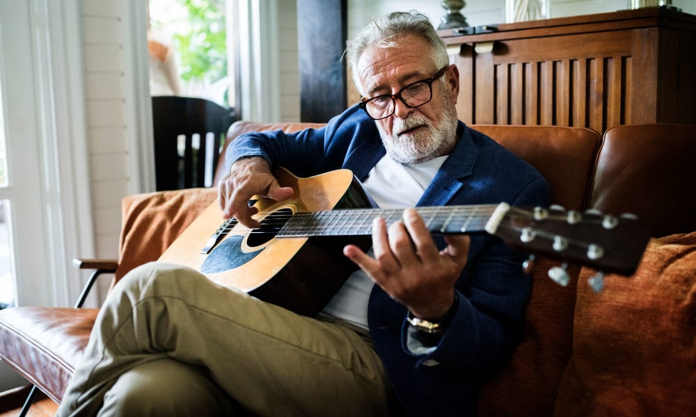 Independent living resident playing an acoustic guitar at Randall Residence