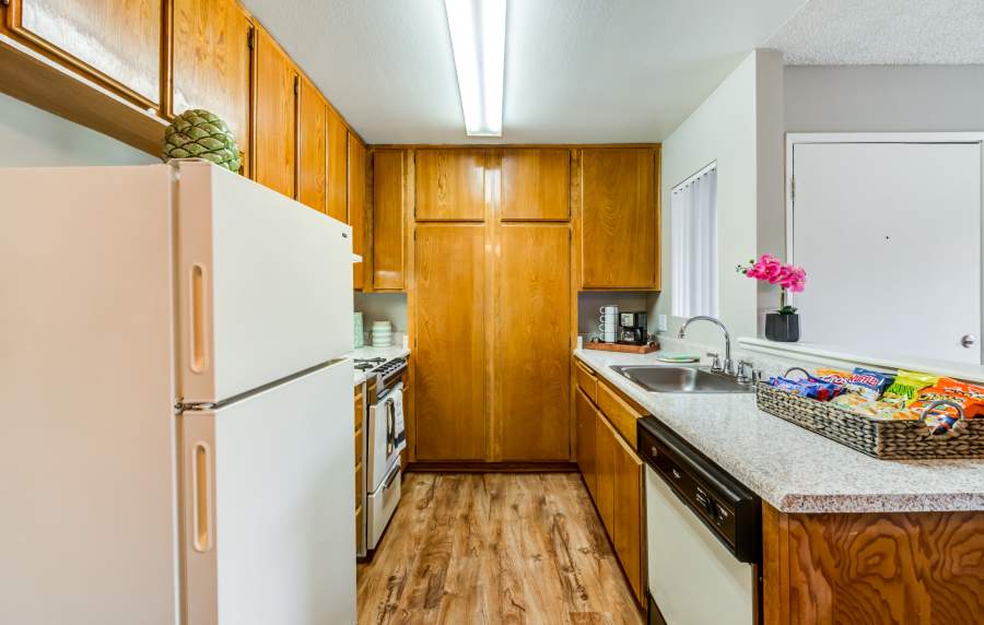 Kitchen with modern appliances and custom wood cabinetry at The Villas at Rowland Heights in Rowland Heights, California