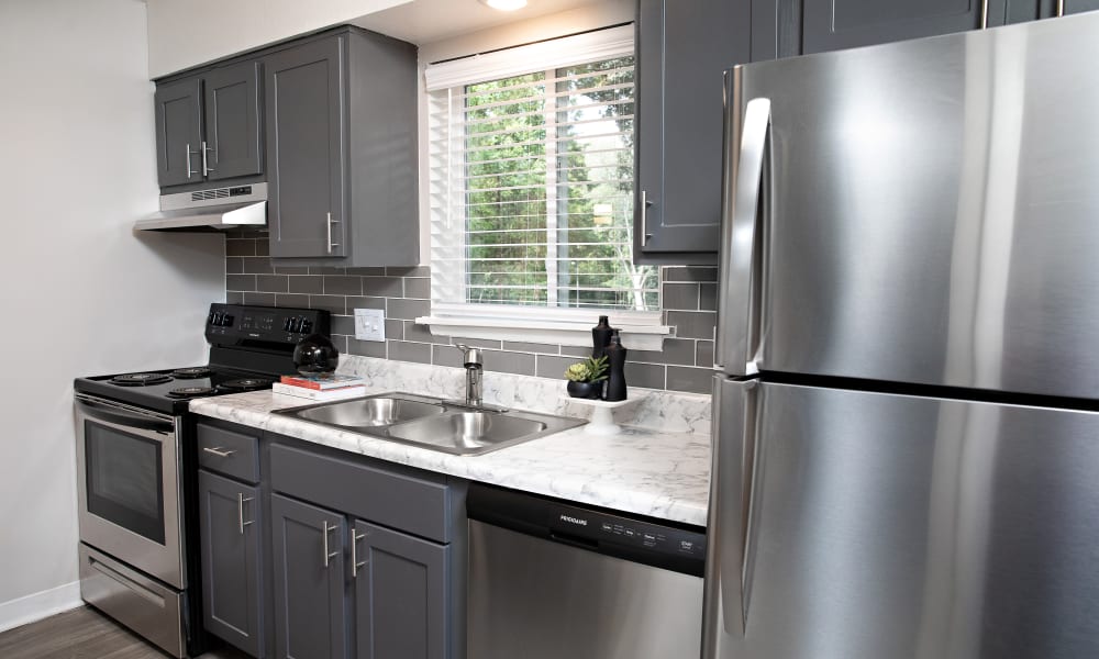 A stainless-steel fridge and sink in an apartment kitchen at Dwell at Carmel in Charlotte, North Carolina