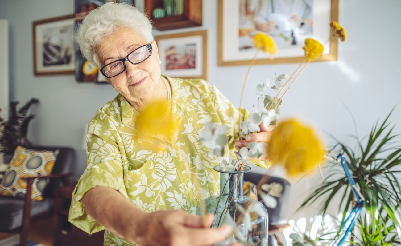 A resident putting flowers in a vase at Merrill Gardens at Tacoma in Tacoma, Washington.