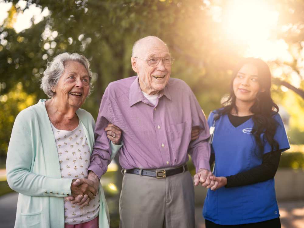 Resident couple walking with a team member at Touchmark