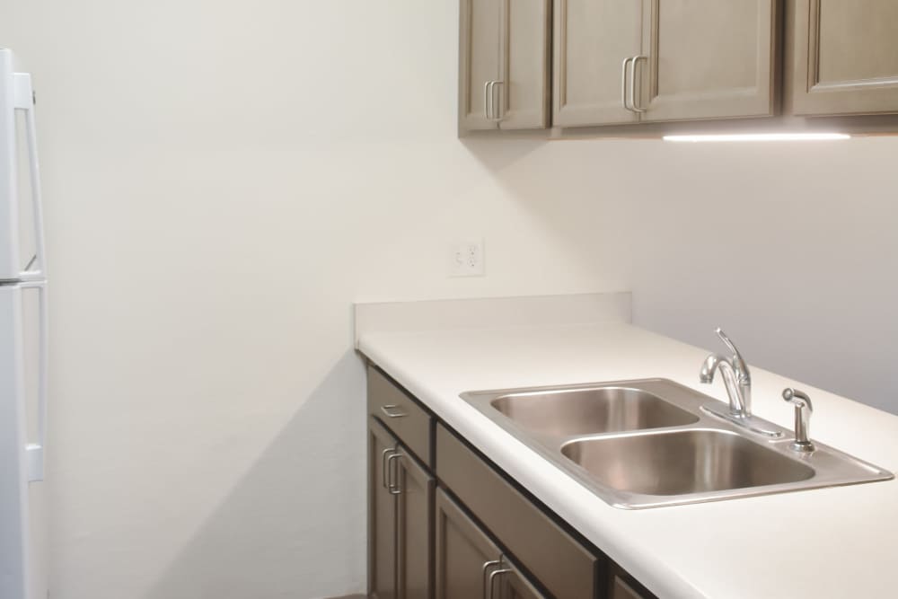Kitchen with a sink and wooden cabinetry at Clairewood Apartments in Saint Clair, Michigan,