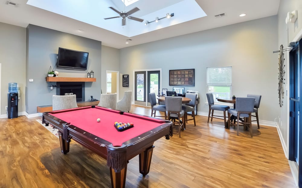 Resident clubhouse with a fireplace and a billiards table at The Greens at Westgate Apartment Homes in York, Pennsylvania